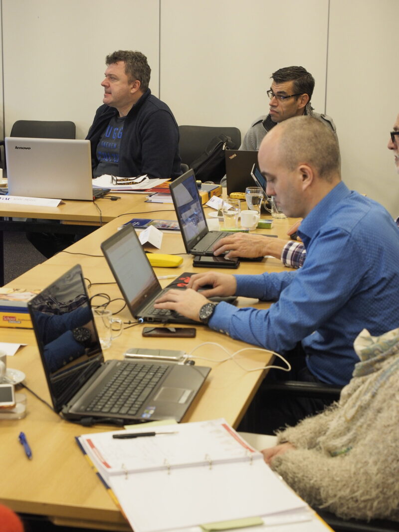 Deelnemers zitten achter hun laptop tijdens een training