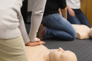 Deelnemers oefenen actief tijdens een EHBO-cursus, in een leeromgeving