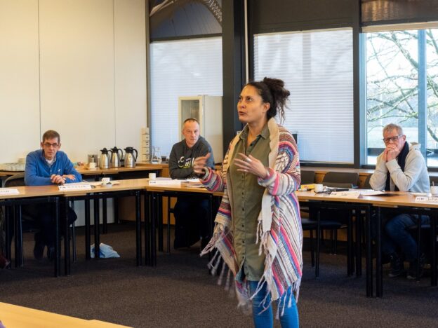 Docent aan het woord tijdens de cursus 'Pedagogisch Conciërge 2 (Verbredingstraining)', terwijl deelnemers aandachtig luisteren