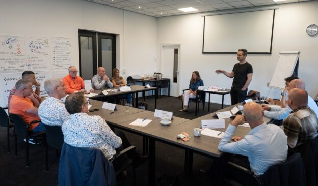Deelnemers luisteren aandachtig naar een docent tijdens de cursus 'Conciërge in het onderwijs'