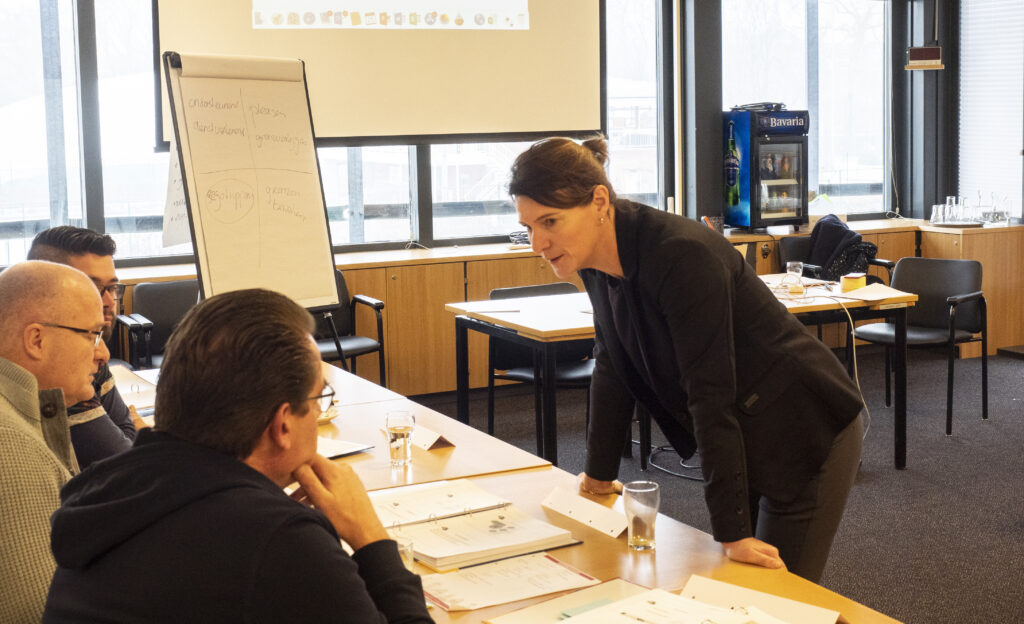 Docent geeft training aan een groep deelnemers