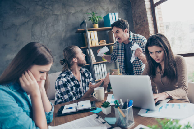 Groep mensen op de werkvloer die in conflict met elkaar zijn